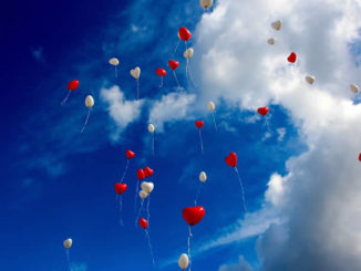 Herzluftballons im blauen Himmel