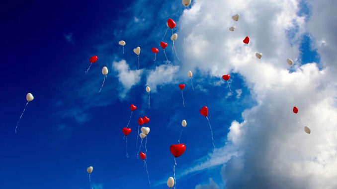 Herzluftballons im blauen Himmel