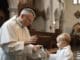 Taufe mit Priester und Kind mit Wasser in Kirche. Hintergründe religiöser Symbole