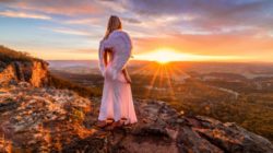 Engelszahlen Bedeutung Frau als Engel die dem Sonnenaufgang entgegen blickt