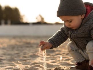 kleiner junge spielt im sand