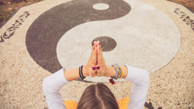 Frau die Yoga vor Yin Yang Zeichen macht