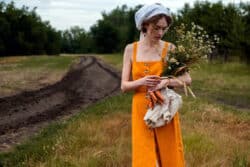 Resilienz als Schlüssel zur inneren Stärke  Frau mit Blumenstrauß auf einem Feld