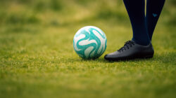 Fußball-Gott Fußball auf dem Spielrasen mit Beinen