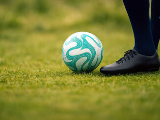Fußball auf dem Spielrasen mit Beinen