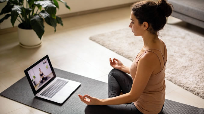 Frau praktiziert Yoga auf dem Boden