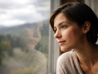 Nachdenklicher Blick einer Frau aus dem Fenster