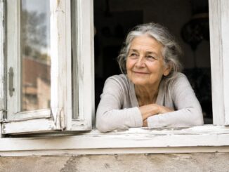 Ältere Frau am verwitterten Fenster