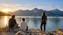 Drei Wanderer am Bergsee im Abendlicht