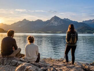 Drei Wanderer am Bergsee im Abendlicht